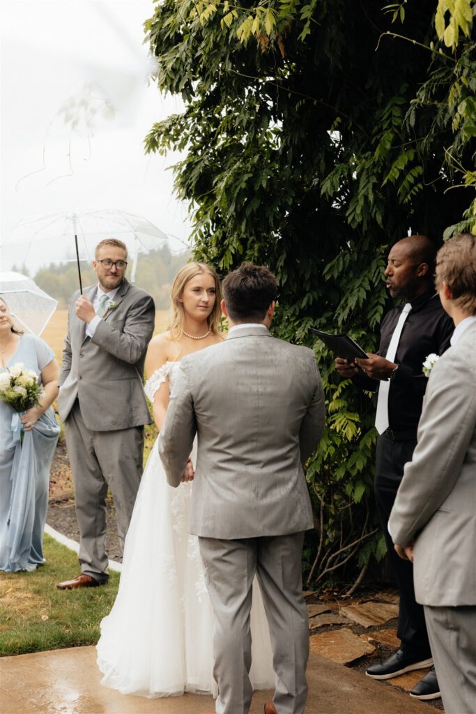 bride and groom holding hands during their ceremony 