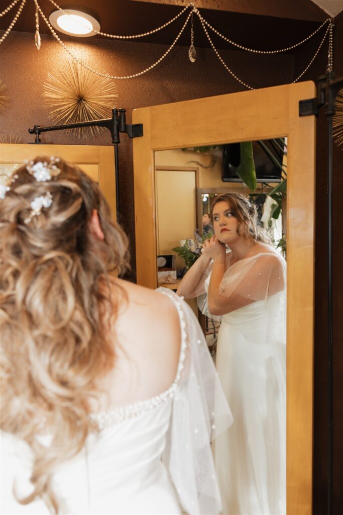 bride putting on her jewelry before her dream ceremony