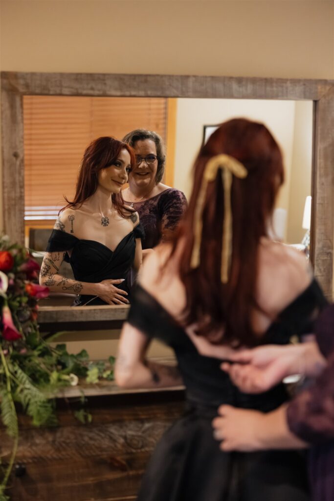 Mother of the bride helping her with her wedding dress