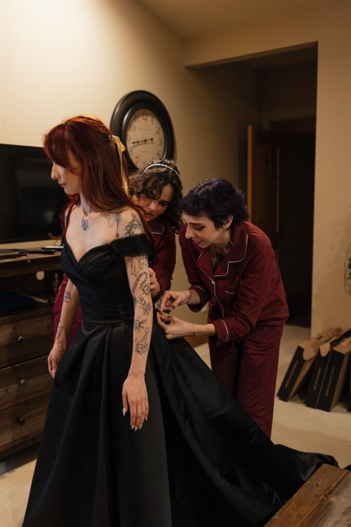 Bridesmaids helping the bride with her wedding dress