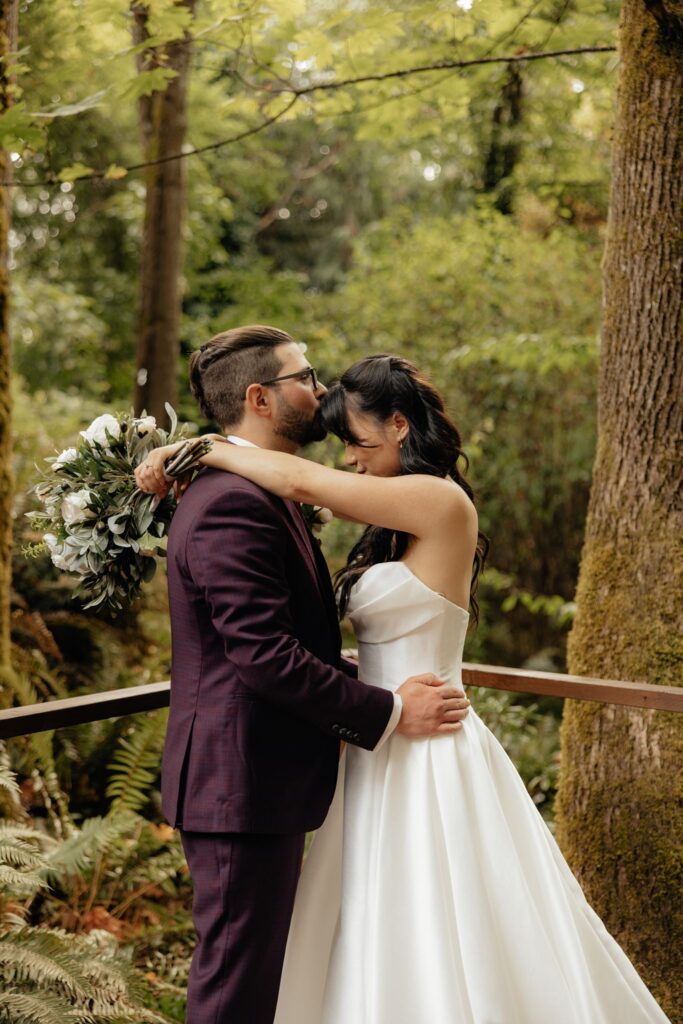 groom kissing the bride on the forehead
