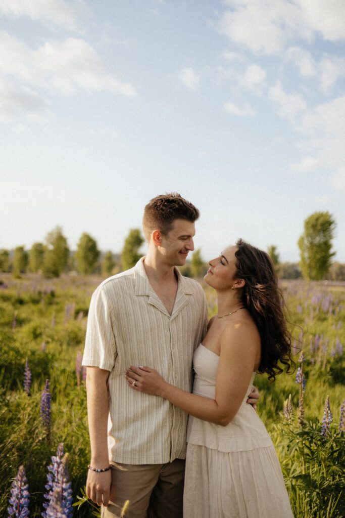 newly engaged couple smiling at each other