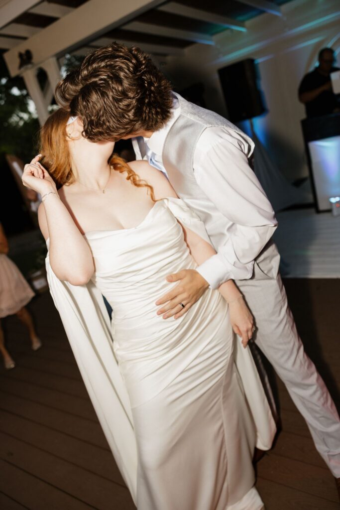 newlyweds kissing at their wedding reception