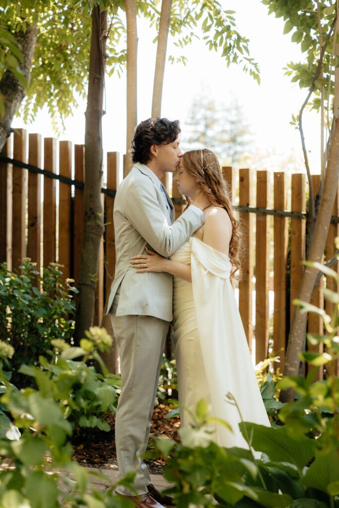 groom kissing the bride on the forehead