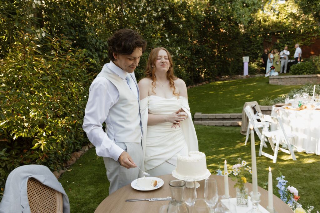 newlyweds trying their wedding cake