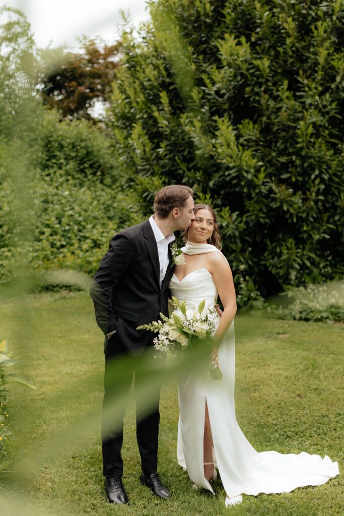cute portrait of the groom kissing the bride on the cheek