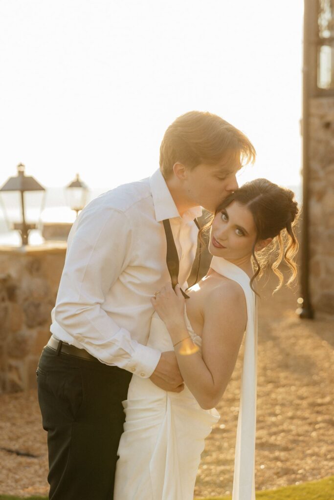 groom kissing the bride on the forehead