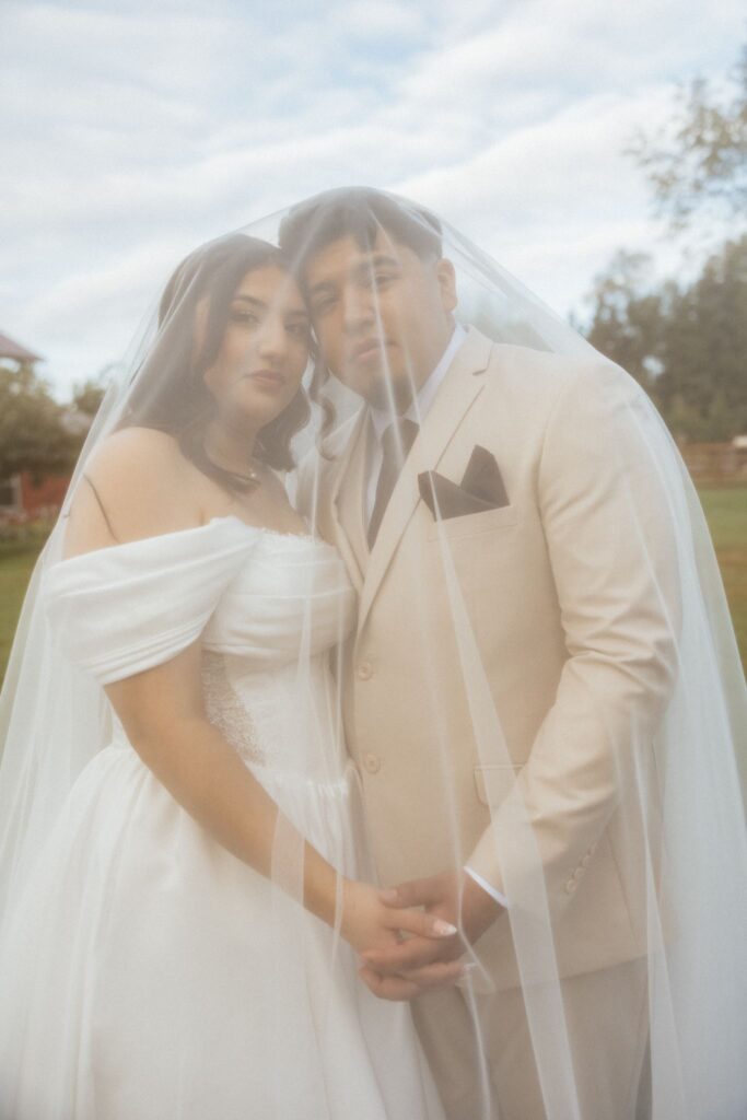 bride and groom smiling at the camera during their photoshoot