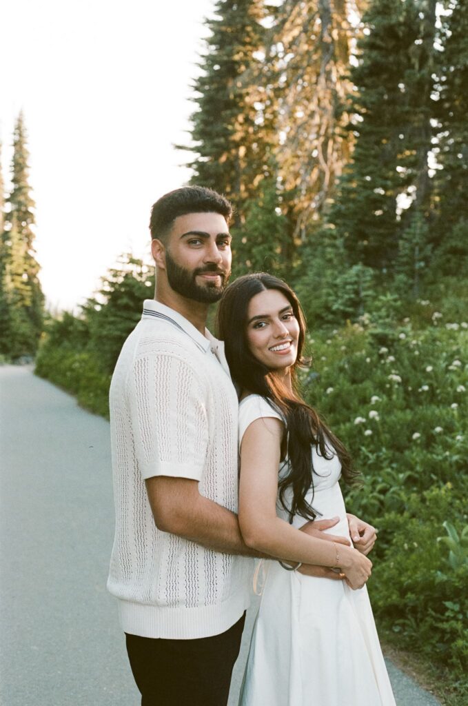 newly engaged couple smiling at the camera during their photoshoot